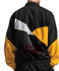 แจ็คเก็ตผ้าร่ม ด้านหลังสีดำลายเฉียงขาว–เหลือง เส้นคัตติ้งคม ขอบเอวจั๊ม กระชับคล่องตัวทั้งวัน