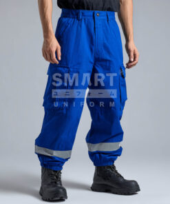 กางเกงยูนิฟอร์มทำงานขายาวสีน้ำเงินสด ทรงกระบอกเอวปกติ มีกระดุมและซิปหน้า พร้อมหูเข็มขัด กระเป๋าข้าง และกระเป๋าคาร์โก้ต้นขาฝาปิดทั้งสองข้าง ช่วงปลายขามีแถบสะท้อนแสงสีเงินคาดรอบ พร้อมปลายขาจั๊มยาง ใส่รองเท้านิรภัยสีดำ ฉากสตูดิโอพื้นเทา