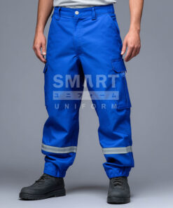 กางเกงยูนิฟอร์มทำงานขายาวสีน้ำเงินสด ทรงกระบอกเอวปกติ มีกระดุมและซิปหน้า พร้อมหูเข็มขัด กระเป๋าข้าง และกระเป๋าคาร์โก้ต้นขาทั้งสองข้างแบบฝาปิด ช่วงปลายขามีจั๊มยางยืดและแถบสะท้อนแสงสีเงินคาดรอบขาทั้งสองข้าง ใส่รองเท้านิรภัยสีดำ ฉากสตูดิโอพื้นเทา