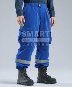 กางเกงยูนิฟอร์มทำงานขายาวสีน้ำเงินสด ทรงตรงเอวสูงเล็กน้อย เอวยางยืดด้านหลังพร้อมกระดุมและซิปหน้า มีหูเข็มขัด กระเป๋าข้าง และกระเป๋าคาร์โก้สองข้างแบบฝาปิด ช่วงปลายขามีแถบสะท้อนแสงสีเงินคาดรอบขาทั้งสองข้าง ปลายขาจั๊มใส่รองเท้านิรภัยสีดำ ฉากสตูดิโอพื้นสีอ่อน