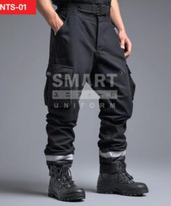 กางเกงยูนิฟอร์มทำงานขายาวสีดำ ทรงหลวมเอวสูง มีกระดุมและซิปหน้า พร้อมหูเข็มขัดรอบเอว กระเป๋าข้าง และกระเป๋าคาร์โก้ต้นขาฝาปิด มีแถบสะท้อนแสงสีเงินรอบปลายขา ใส่กับรองเท้านิรภัยสีดำ ถ่ายสตูดิโอพื้นเทา