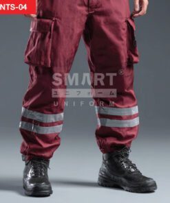 รายละเอียดกางเกงยูนิฟอร์มทำงานสีแดงเลือดหมู เห็นกระเป๋าคาร์โก้ฝาปิดที่ต้นขา และแถบสะท้อนแสงสีเงินคาดรอบปลายขา เนื้อผ้าเรียบและรอยย่นจากการสวมใส่ ใส่รองเท้านิรภัยสีดำ ถ่ายสตูดิโอพื้นเทา