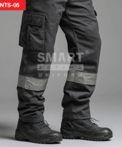 รายละเอียดกางเกงยูนิฟอร์มทำงานสีเทาเข้ม เห็นกระเป๋าคาร์โก้ฝาปิดที่ต้นขา ตะเข็บเสริมความทน และแถบสะท้อนแสงสีเงินคาดรอบปลายขา ใส่รองเท้านิรภัยสีดำ ถ่ายสตูดิโอพื้นเทา