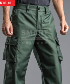 รายละเอียดกางเกงยูนิฟอร์มทำงานสีเขียวเข้ม เห็นขอบเอวพร้อมหูเข็มขัด กระดุมหน้าและแนวซิป ตะเข็บเย็บเสริมความทน และกระเป๋าคาร์โก้ต้นขาฝาปิดด้านข้างทั้งซ้ายและขวา โทนงานช่างเรียบสุภาพ ถ่ายสตูดิโอพื้นเทา