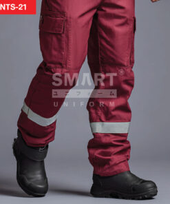 รายละเอียดกางเกงยูนิฟอร์มทำงานสีแดงเลือดหมู เห็นกระเป๋าคาร์โก้ฝาปิดที่ต้นขา แนวตะเข็บเสริมความทน และแถบสะท้อนแสงสีเงินคาดรอบช่วงปลายขา ใส่รองเท้านิรภัยสีดำ ถ่ายสตูดิโอพื้นเทาเข้ม
