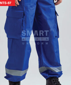 ซูมดีเทลกางเกงช็อปช่าง สีน้ำเงินคม กระเป๋าข้างฝาปิด ตะเข็บแน่น แถบสะท้อนแสง ชัดเจน บริเวณ ต้นขา เนื้อผ้าเรียบ โทนสตูดิโอ