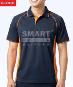 เสื้อโปโลยูนิฟอร์มสีน้ำเงินกรมท่า ตัดต่อแถบข้างสีส้ม ปกโปโลขลิบเส้นส้ม สาบคอด้านในสีส้ม กระดุมหน้า แขนแร็กแลนเดินเส้นตะเข็บสีส้ม ถ่ายสตูดิโอพื้นหลังสีอ่อน