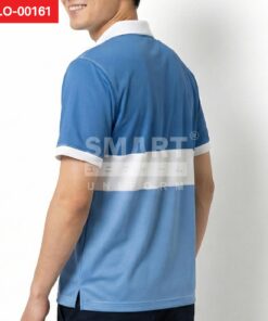 ด้านหลังเสื้อโปโลยูนิฟอร์มสีน้ำเงินมีแถบคาดสีขาวกว้างพาดรอบตัว คอปกและปลายแขนสีขาวช่วยคุมลุคให้ดูสะอาดตา ถ่ายสตูดิโอพื้นหลังสีอ่อน