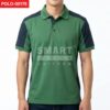 เสื้อโปโลยูนิฟอร์มสีเขียวตัดต่อแขนและหัวไหล่สีกรมท่า คอปกสีเขียว กระดุมหน้าสีเข้ม ทรงตรงใส่ทำงาน ถ่ายสตูดิโอพื้นหลังสีอ่อน