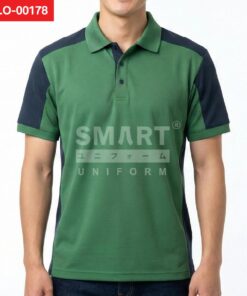 เสื้อโปโลยูนิฟอร์มสีเขียวตัดต่อแขนและหัวไหล่สีกรมท่า คอปกสีเขียว กระดุมหน้าสีเข้ม ทรงตรงใส่ทำงาน ถ่ายสตูดิโอพื้นหลังสีอ่อน